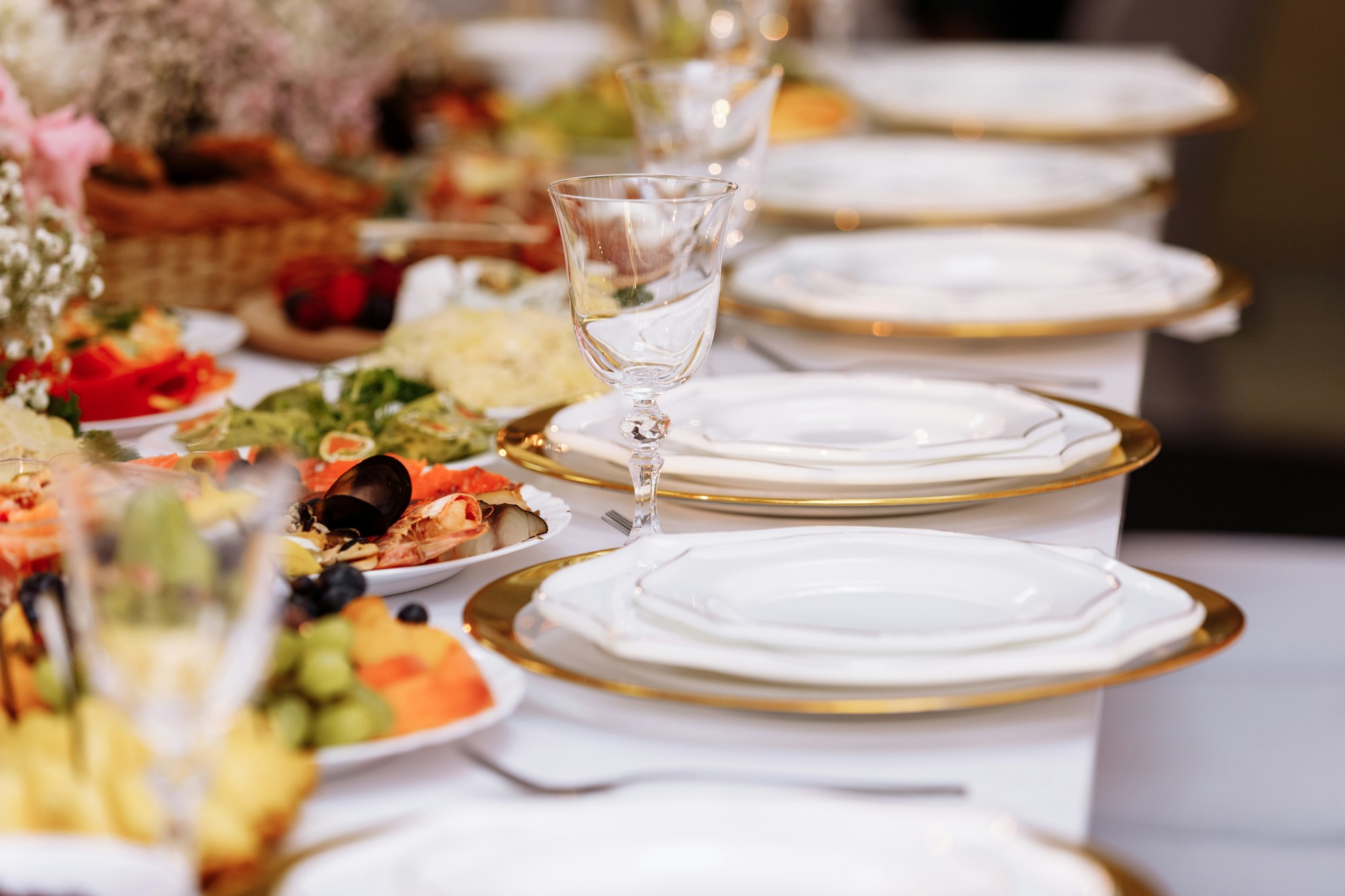 a table with a tablecloth, a beautiful serving of white dishes, a beautiful plate, dinner in